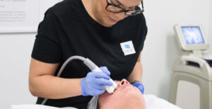 An aesthetician performing a procedure on a patient.