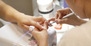 A woman getting her fingernails manicured.