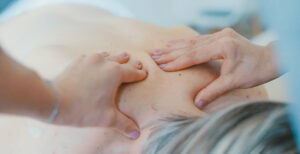 A back being massaged with two hands.