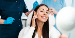 woman sitting in a doctors office pointing at her cheek for botox or cosmetic injections