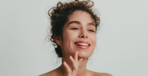 woman smiling and touching her chin