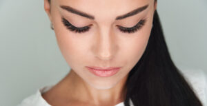 woman looking down with a full set of eyelash extensions on her eyelids